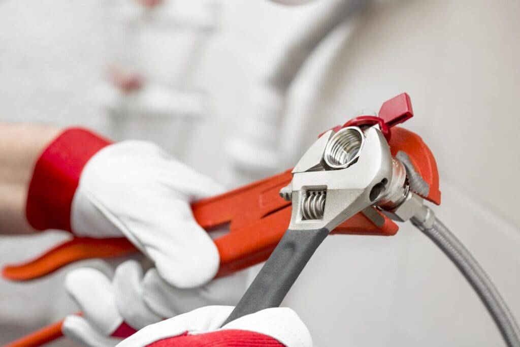 Plumber holding pipe wrenches for an emergency repair in Fontana