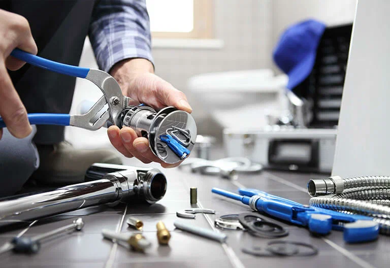 Technician repairing a plumbing fixture with professional tools in Fontana