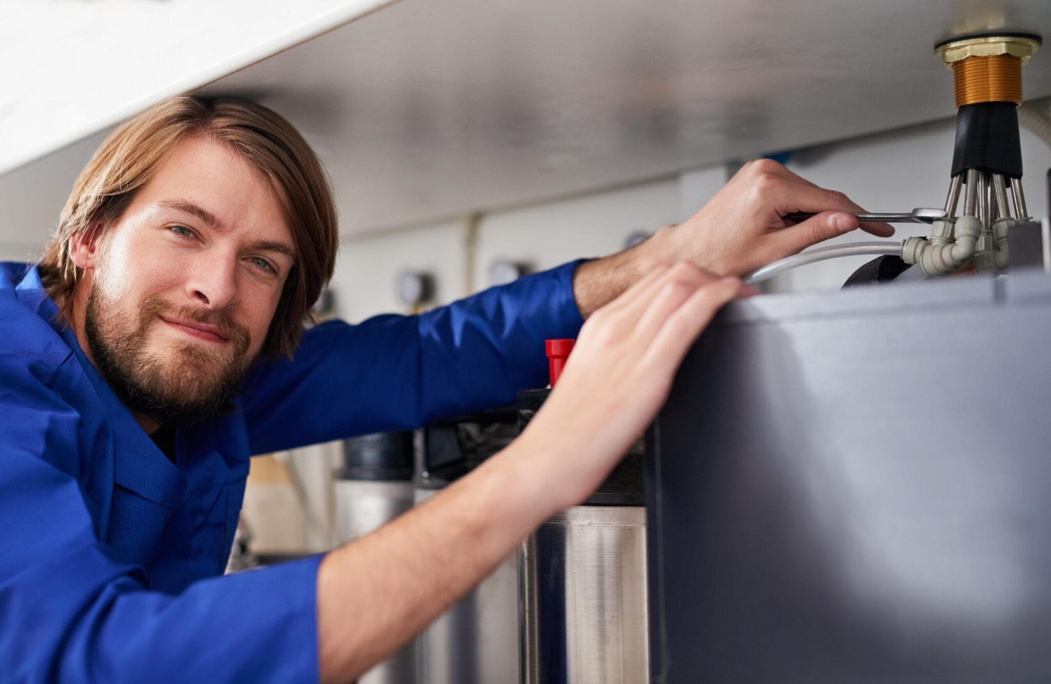 Technician servicing a residential water heater tank in Fontana